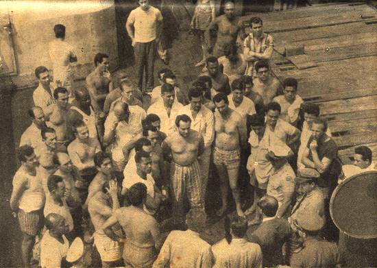Os presos políticos no convés do navio ouvem os representantes da repressão.