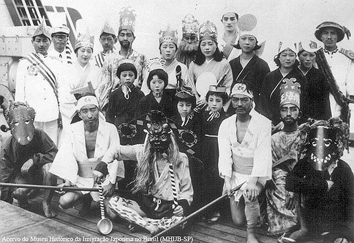 Uma bela cena da viagem ao Brasil, um grupo de imigrantes vestidos com coroas, máscaras e kimonos para o Sekido Matsuri no vapor La Plata Maru. Pode-se observar as máscaras, provavelmente estes são aqueles que estão no papel de oni.