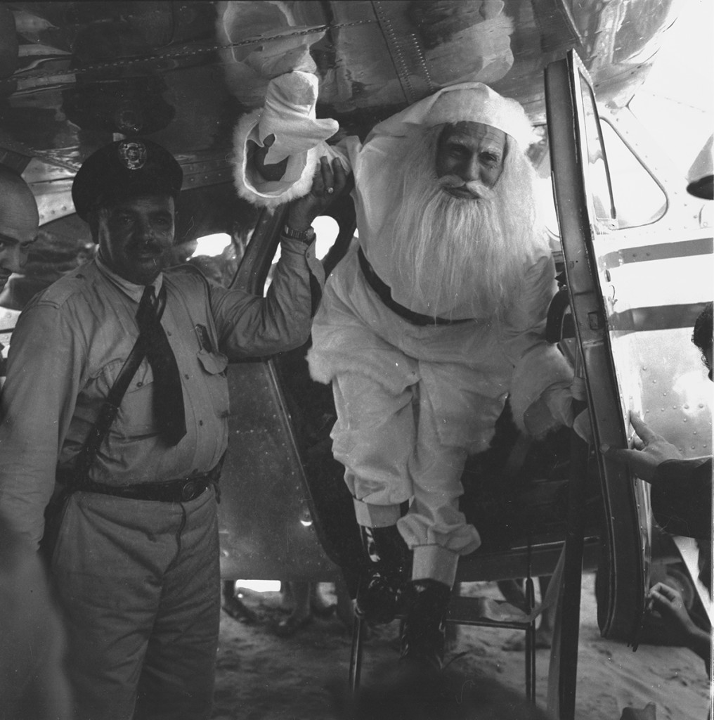 Papai Noel de 1957, chegando de avião. Na recepção, o popular guarda civil Mussi, o “bigode”.